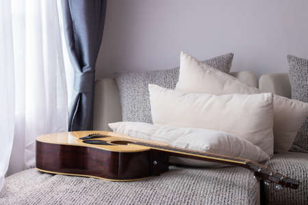 white bed with guitar in living room.の写真素材