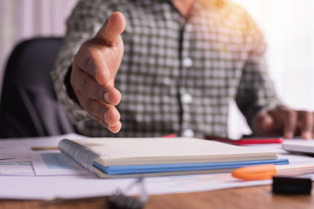 Office desk with businessman handshake holding. Commitment concept.