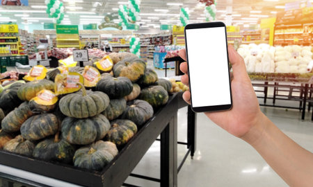 businessman holding blank screen for text on smartphone, mobile, cell phone with blurry pumpkin...
