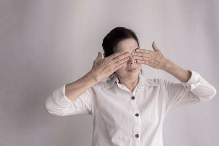 asian elderly woman Stinging eyes on isolated background, concept of health care.の写真素材