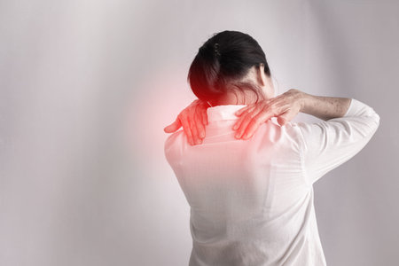 Shoulder pain woman on isolated white background, back view, concept of healthcare.