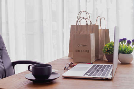 wood office table with shopping bag and laptop, concept of online shopping, toptable.の写真素材