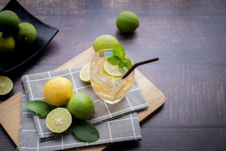wood table with freshly squeezed lemon juice with mint and sliced lemon, view on top.