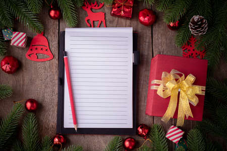 Blank screen for text notepad paper with Christmas decorations, gift boxes on wooden board, view from above.の写真素材