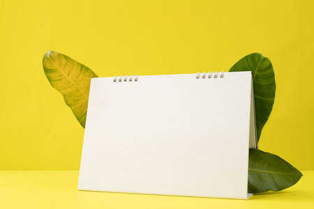 Blank screen Calendar paper on yellow background with leaves frame.