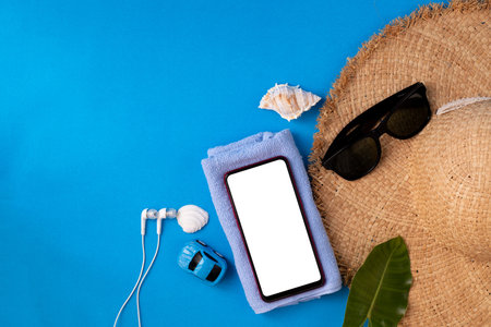 Blank screen on smart phone with Traveller accessories in summer season, view from above table.