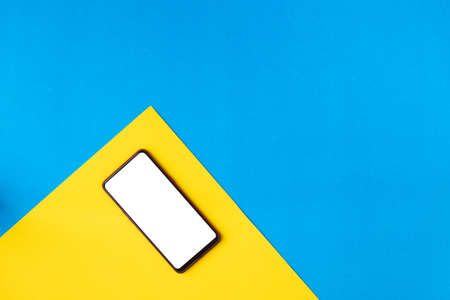 Flat lay Mockup smartphone on yellow background, view from above table.の写真素材