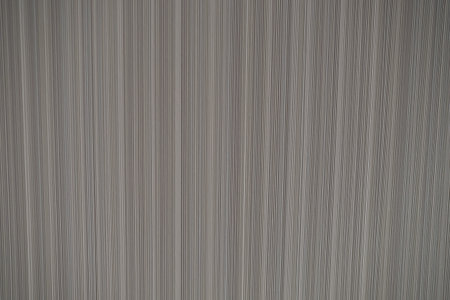 Close-up of vertical striped fabric texture in shades of grey, creating a linear pattern