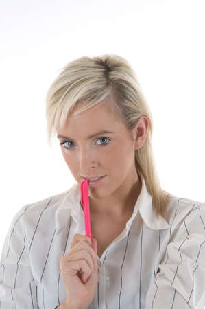 An attractive young secretary holding a pink penの写真素材