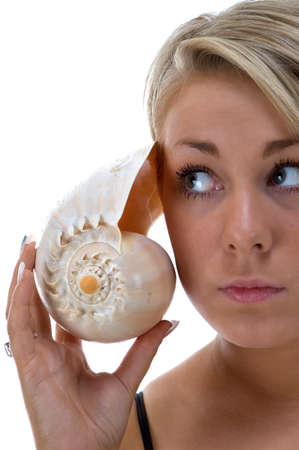 Girl listening to a conch shellの写真素材