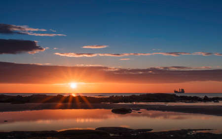 Sunrise over Tynemouth with ship on the horizonの写真素材