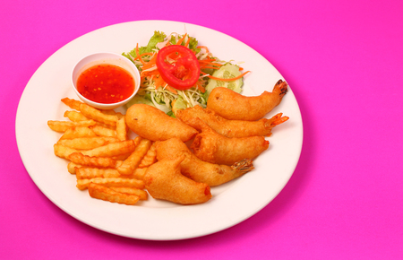 deep fried prawns with salad and chilli with a pink backgroundの写真素材
