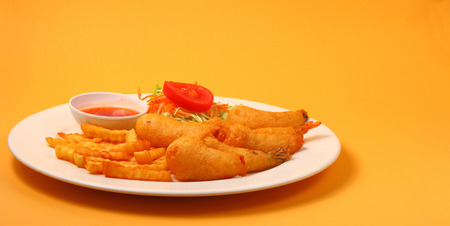 deep fried prawns with salad and chilli with a orange backgroundの写真素材