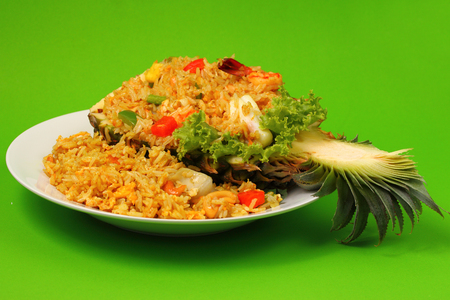 seafood and baked rice in pineapple with a green backgroundの写真素材