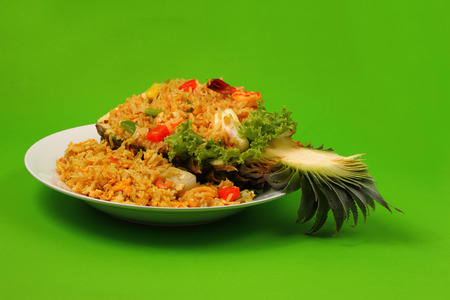 seafood and baked rice in pineapple with a green backgroundの写真素材