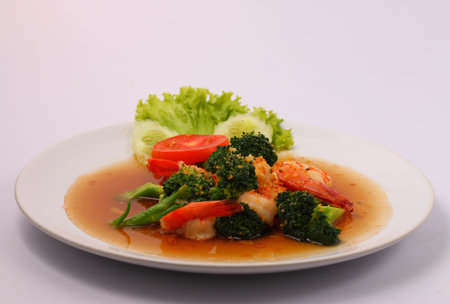 Shrimp and broccoli stir fry in sauce with a white backgroundの写真素材
