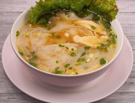 Glass noodle soup with chicken and beansprouts on a wood table top backgroundの写真素材