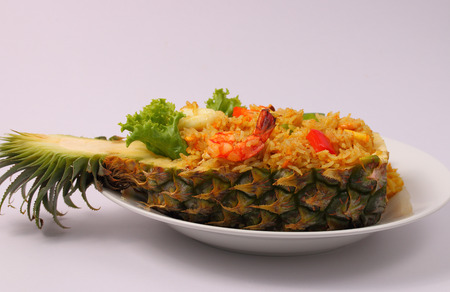 seafood and baked rice in pineapple with a white backgroundの写真素材