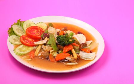 Thailand vegetable stir fry in sauce on a pink backgroundの写真素材