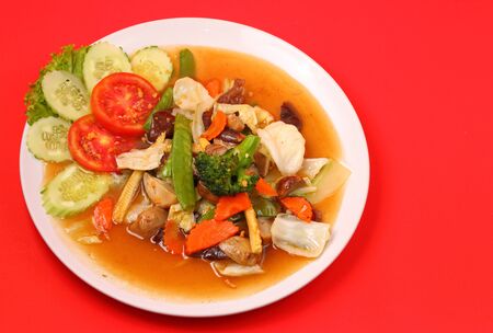 Thailand vegetable stir fry in sauce on a red backgroundの写真素材