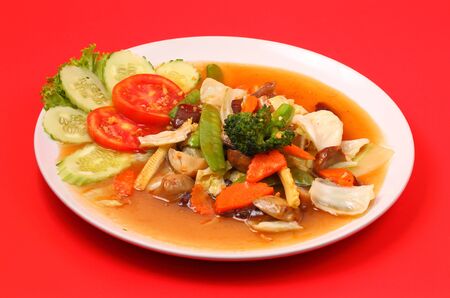 Thailand vegetable stir fry in sauce on a red backgroundの写真素材