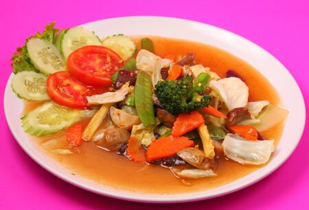 Thailand vegetable stir fry in sauce on a pink backgroundの写真素材