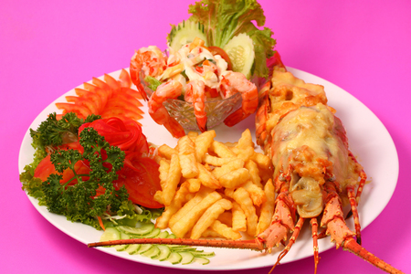 Lobster thermidor, baked lobster served with shrimp cocktail and French friesの写真素材