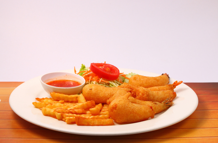 deep fried prawns with salad and chilli with a white background on wood table topの写真素材