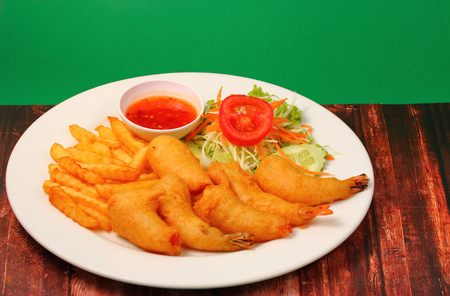deep fried prawns with salad and chilli with a green background on wood table topの写真素材