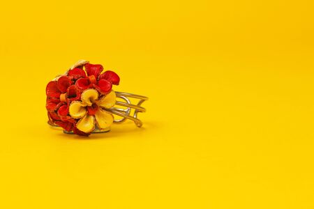 Flower decorated ring being displayed on a yellow backgroundの写真素材