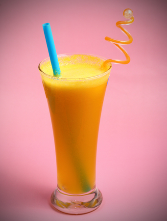 pineapple juice in glass on pink backgroundの写真素材