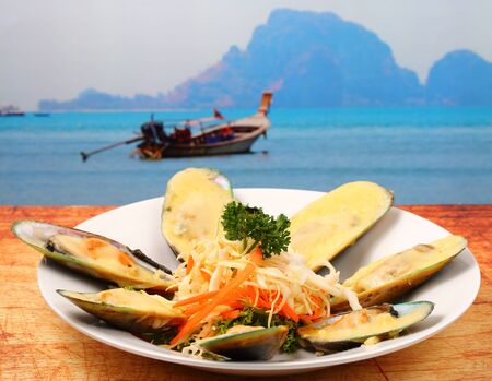 new Zealand mussels in cheese sauce on a wood table top on the beachの写真素材