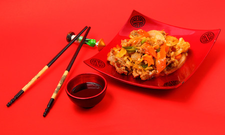 beef stir fry with ginger on a red backgroundの写真素材