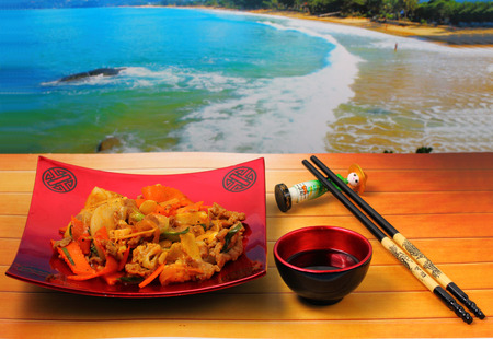beef stir fry with ginger Vietnam style on a wood table top by the beachの写真素材