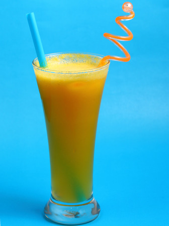 pineapple juice in glass on blue backgroundの写真素材