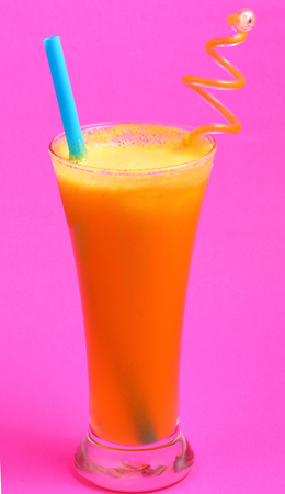 pineapple juice in glass on pink backgroundの写真素材