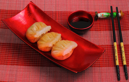 steamed shrimp dumplings served on a traditional bamboo place matの写真素材