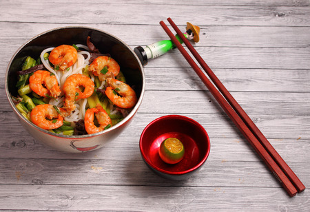 Vietnamese shrimp and rice noodles soup pho, served on a wood table topの写真素材