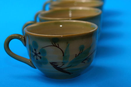 Asian style tea cups in a row  on a blue backgroundの写真素材