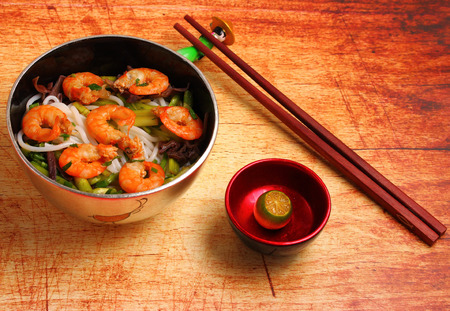 Vietnamese shrimp and rice noodles soup pho, served on a wood table topの写真素材