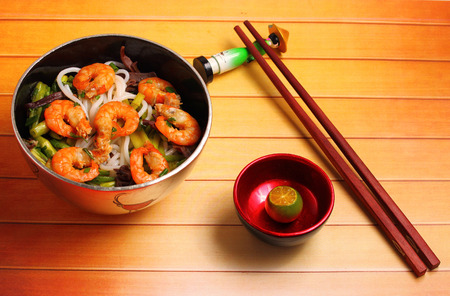 Vietnamese shrimp and rice noodles soup pho, served on a wood table topの写真素材