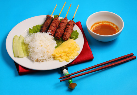 Vietnam beef on sticks served with salad with a blue backgroundの写真素材