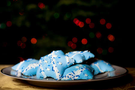 Hanukah Blue Star shaped Cookies with the Bokeh of Christmas tree lights behindの写真素材