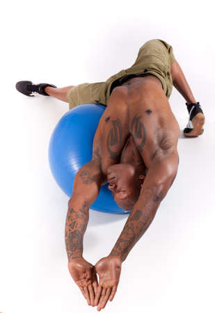Athletic Man Stretching on an exercise Ballの写真素材