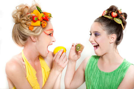 Beautiful Woman and child with hot a mixture of fresh vegetables and fruit and creative make-upの写真素材