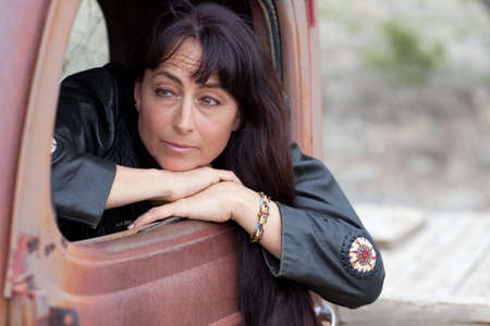 Beautiful Middle Aged Woman in a Vintage truck smiling confidentlyの写真素材