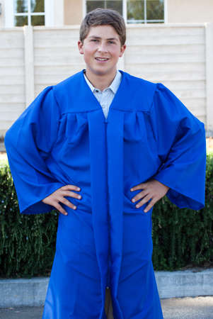 Teenager  in a Blue Robe smiling proudly on his graduation dayの写真素材