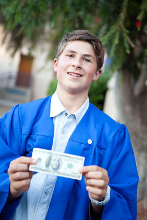 Teenager  holding money on his graduation dayの写真素材