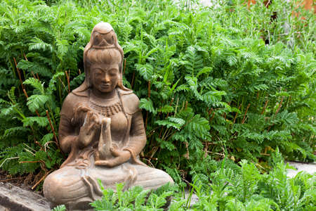 Ancient Female Statue providing offerings in a gardenの写真素材