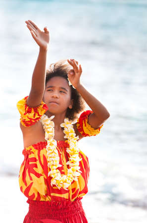 Pretty Hula Girl dancing at the beach in traditional dress at the beach wearing a handmade flower leiの写真素材